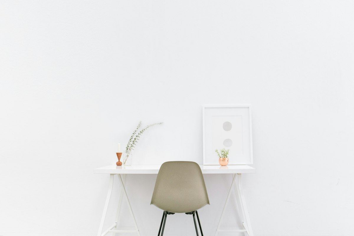 A white desk and chair in a clean, minimal room