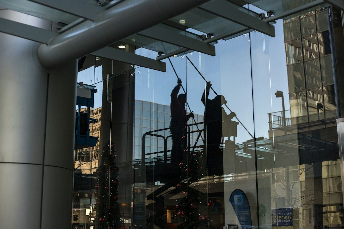 Window cleaners working on the glass front of an office building