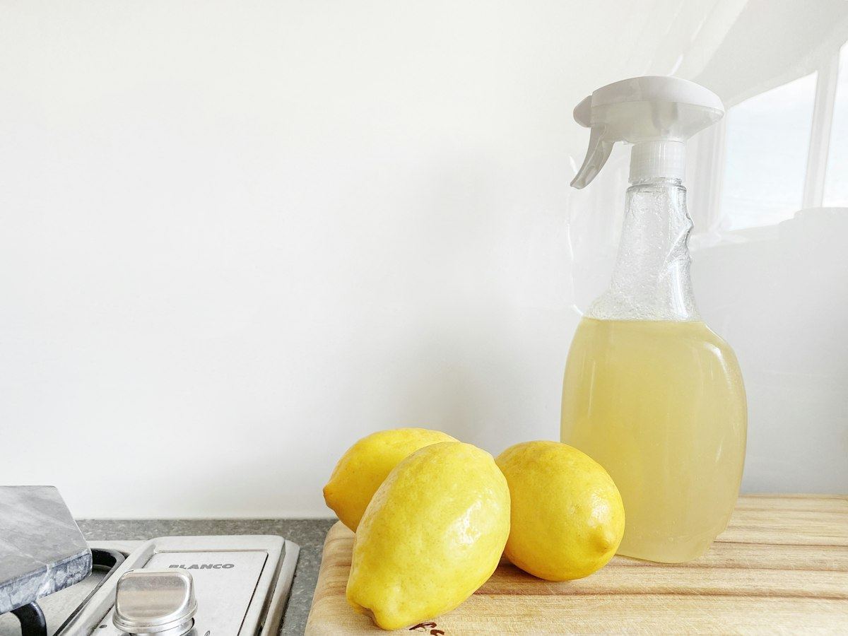 A spray bottle of homemade cleaner next to lemons