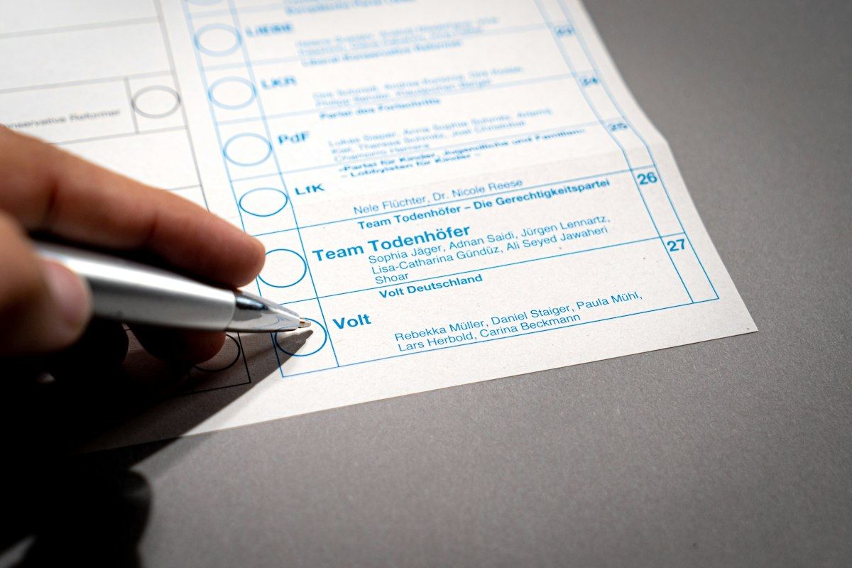 A hand holding a pen over a printed form