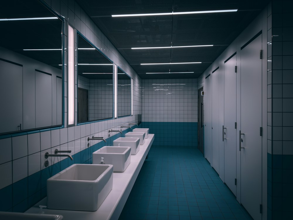A clean commercial washroom with basins and cubicles
