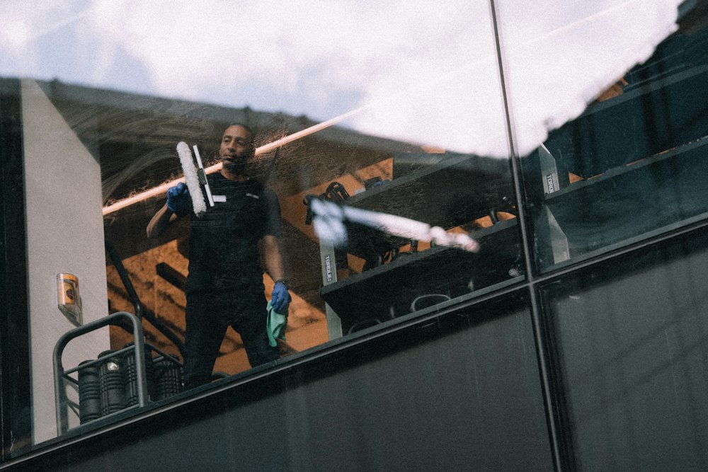 A window cleaner using a squeegee on the glass of a building