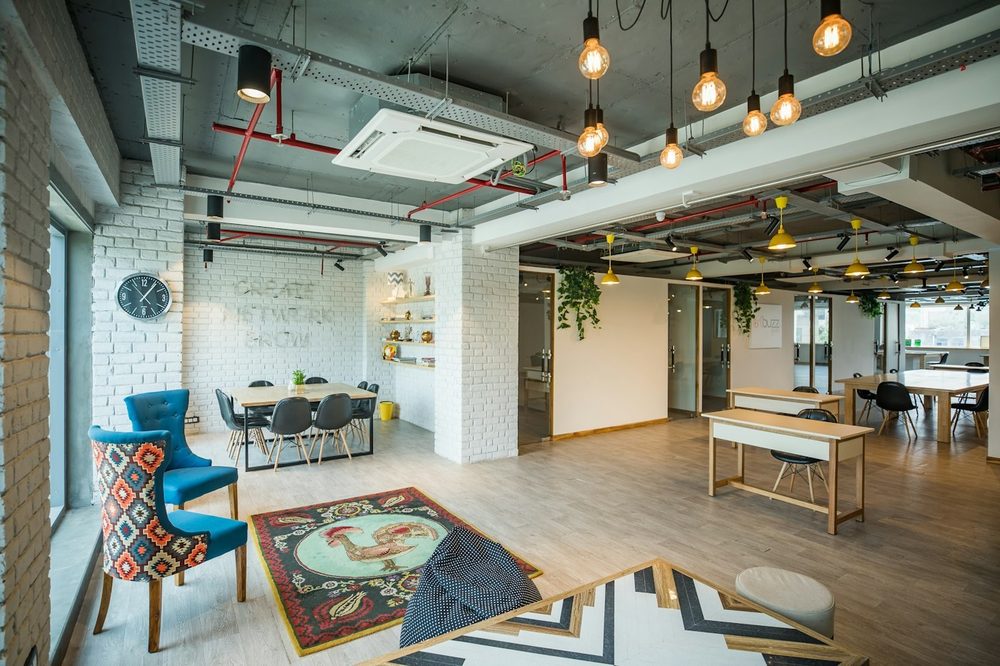 A colourful, creative office space with exposed beams and hanging lights, the kind of Covent Garden office we clean