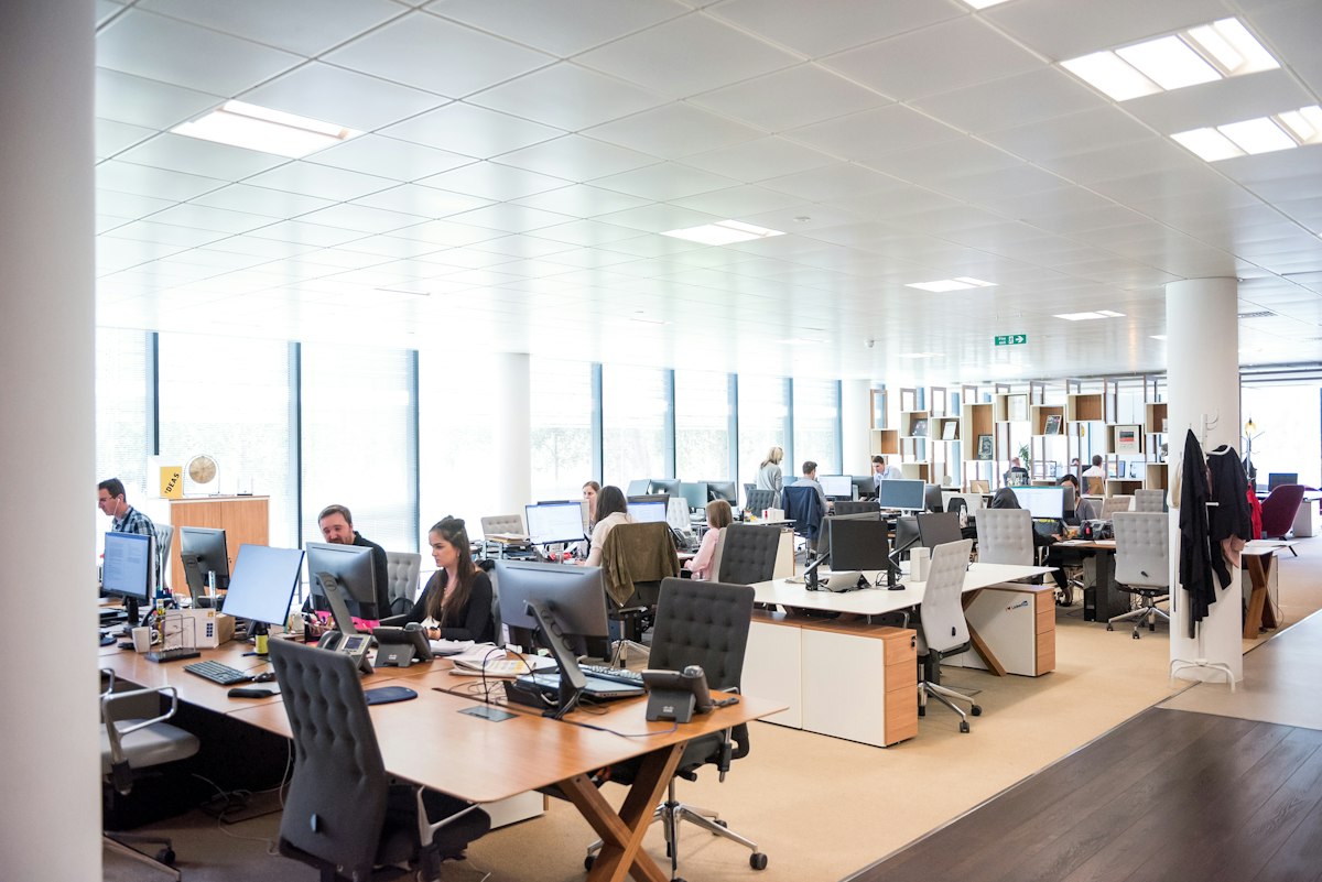 A bright open-plan office with rows of desks and long windows, the kind of Kennington workplace we clean
