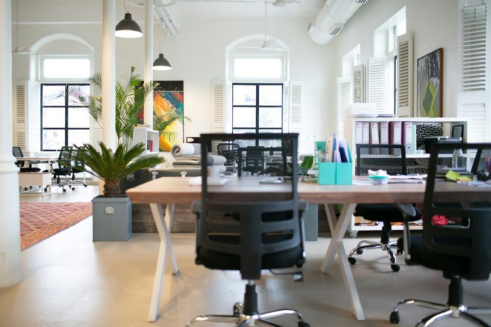 A bright open-plan office with arched windows and long desks, the kind of Mayfair office we clean