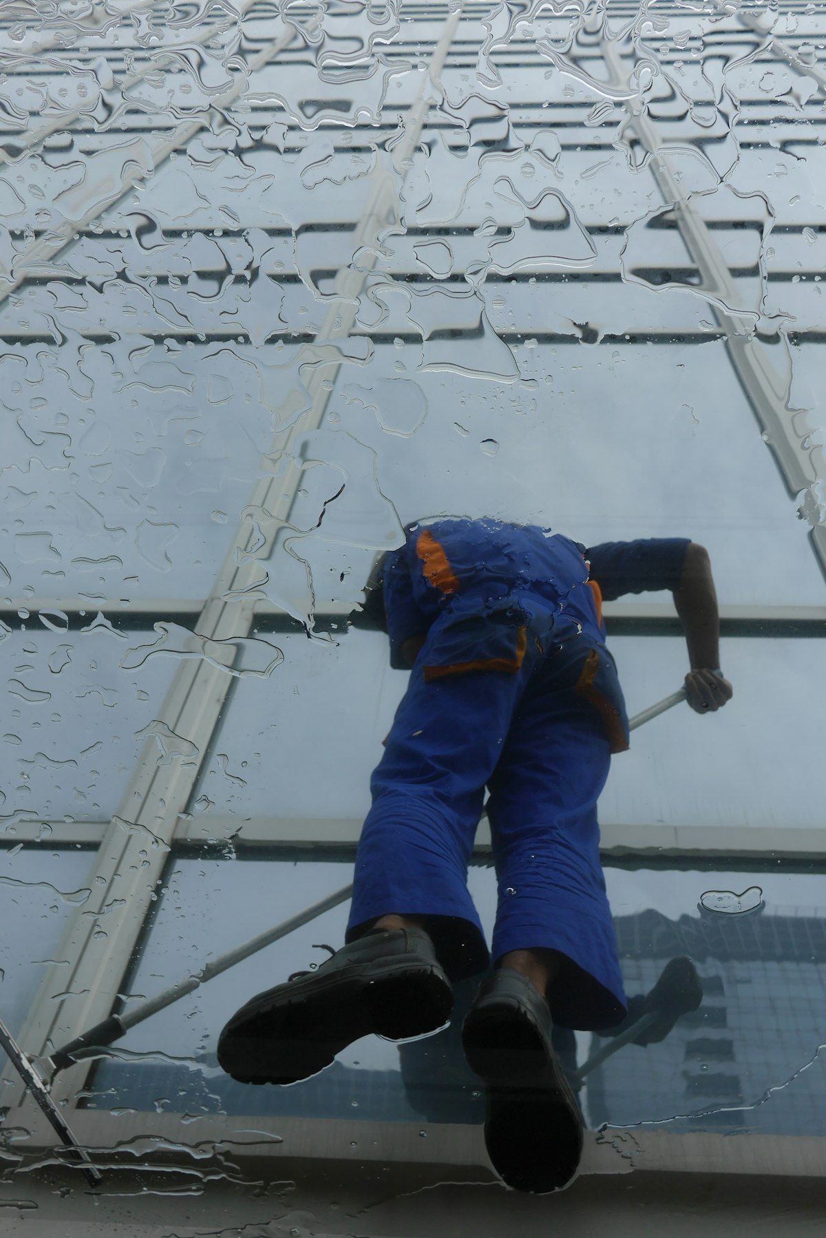 A window cleaner working on the glass of a tall building